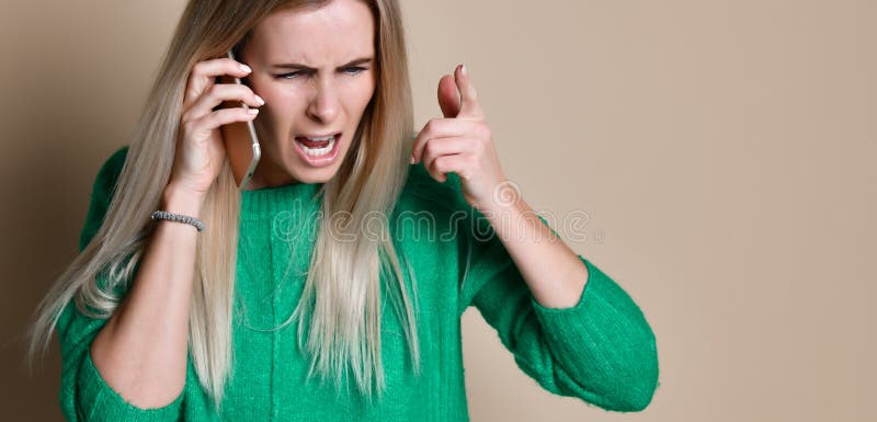 Jovem mulher irritada que discute a fala no telefone imagem de stock Jovem mulher irritada que discute a fala no telefone imagem de stock