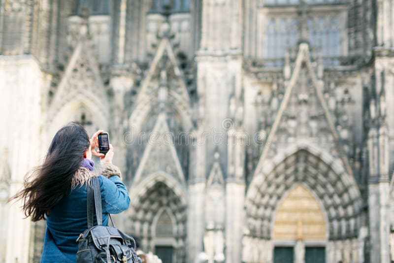 Jovem mulher na catedral do ` s de Front Of Cologne imagens de stock