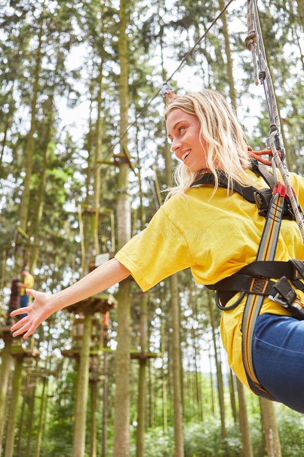 Jovem mulher na floresta de escalada ao rappelling imagens de stock Jovem mulher na floresta de escalada ao rappelling imagens de stock