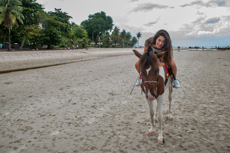 Jovem mulher na praia que abraça o cavalo foto de stock royalty free Jovem mulher na praia que abraça o cavalo foto de stock royalty free