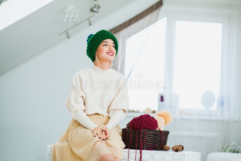 Jovem mulher no chapéu tricotado manualmente morno em casa Senhora bonita no tampão verde grande, sorrindo felizmente fotos de stock Jovem mulher no chapéu tricotado manualmente morno em casa Senhora bonita no tampão verde grande, sorrindo felizmente fotos de stock