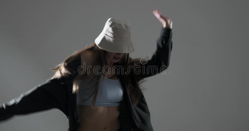 Jovem mulher num chapéu dançando hip hop