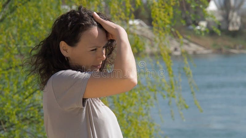 Jovem mulher pelo rio Menina na água com cabelo tornando-se Um dia ensolarado da mola