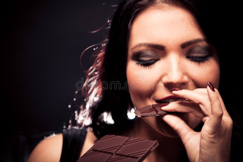 Jovem mulher que aprecia o chocolate imagens de stock royalty free