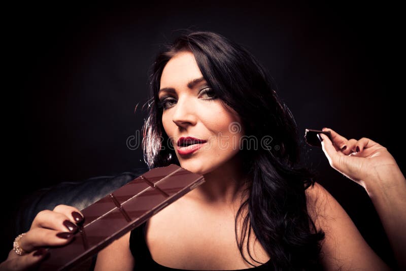 Jovem mulher que aprecia o chocolate fotografia de stock royalty free