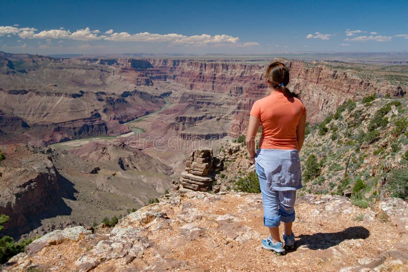 Jovem mulher que aprecia a opinião de Grand Canyon da opinião do deserto foto de stock Jovem mulher que aprecia a opinião de Grand Canyon da opinião do deserto foto de stock
