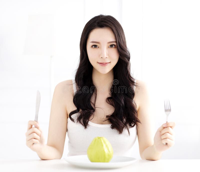 Jovem mulher que come a goiaba verde imagens de stock royalty free