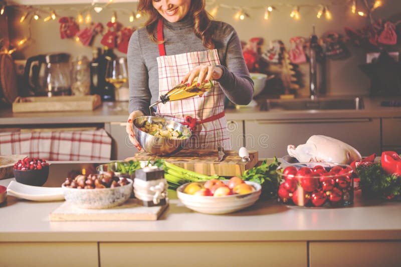 Jovem mulher que cozinha na cozinha Alimento saudável para o pato ou o ganso enchido Natal imagem de stock royalty free