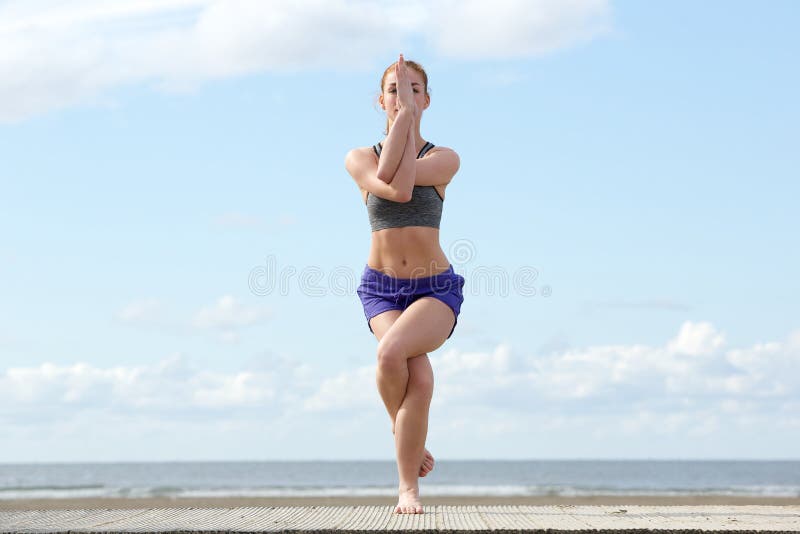 Jovem mulher que equilibra na posição da ioga fotos de stock royalty free Jovem mulher que equilibra na posição da ioga fotos de stock royalty free