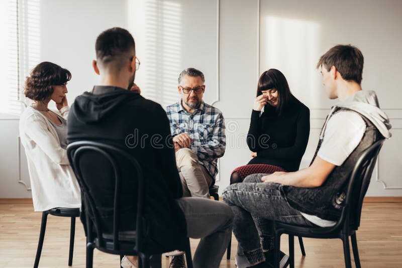 Jovem mulher que grita durante a reunião de grupo de apoio dos viúvos fotografia de stock Jovem mulher que grita durante a reunião de grupo de apoio dos viúvos fotografia de stock