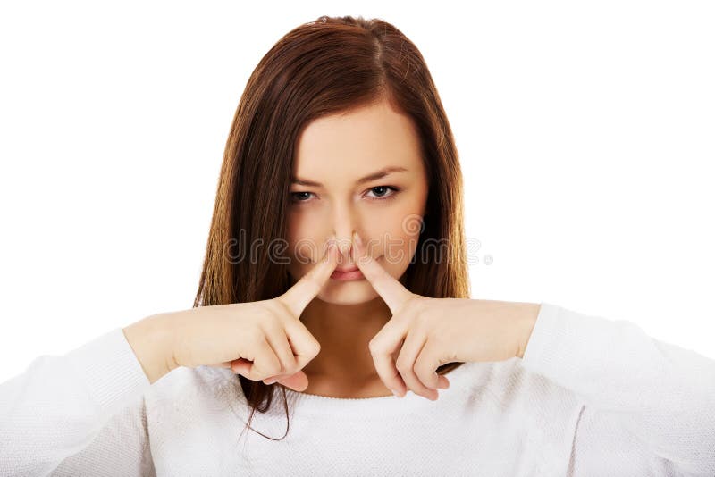 Jovem mulher que guarda seu nariz devido a um cheiro mau imagem de stock Jovem mulher que guarda seu nariz devido a um cheiro mau imagem de stock