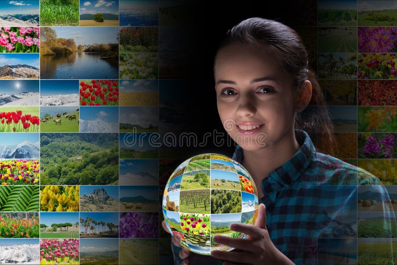 A jovem mulher que guarda a terra com fotos da natureza imagens de stock A jovem mulher que guarda a terra com fotos da natureza imagens de stock