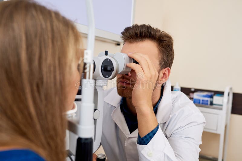 Jovem mulher que obtém o teste do olho em optometristas imagens de stock royalty free Jovem mulher que obtém o teste do olho em optometristas imagens de stock royalty free