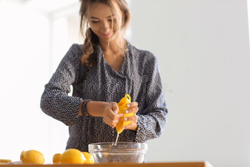 Jovem mulher que prepara a limonada fresca em casa fotografia de stock royalty free Jovem mulher que prepara a limonada fresca em casa fotografia de stock royalty free