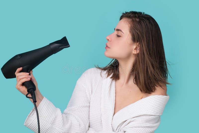 mulher jovem e bonita usando secador de cabelo no salão de