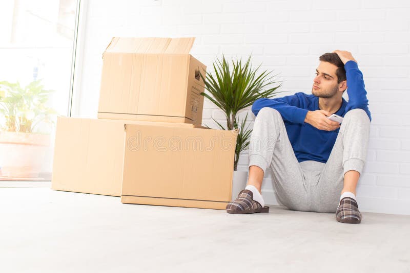 Jovem no apartamento com mudança foto de stock