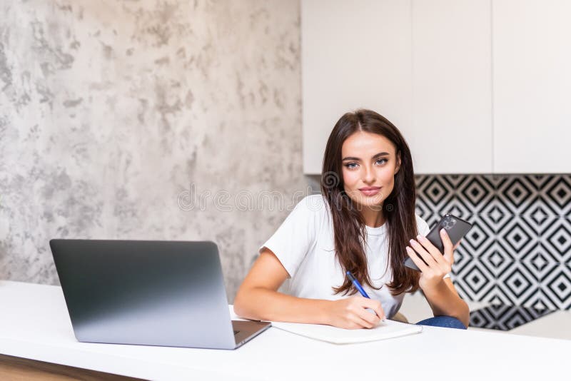 Jovem trabalhadora doméstica. freelancer usa internet e notebook para celular fotos de stock