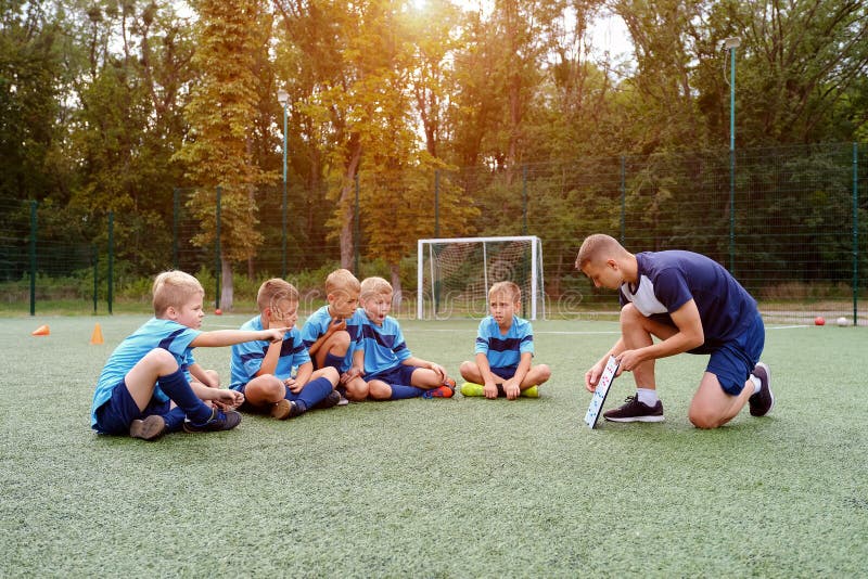 Equipe De Futebol Infantil Se Abraça No Campo De Futebol Antes Do