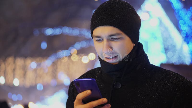 Jovem usando aplicativo no smartphone à noite na cidade