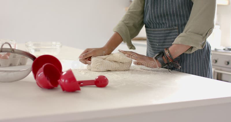 Joven afroamericana amasando masa en la cocina metrajes
