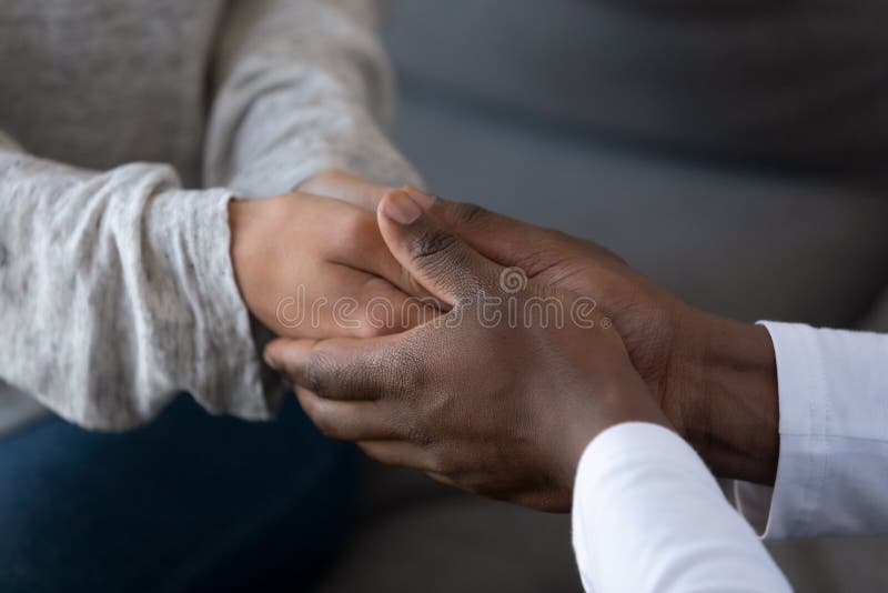 Close up young african american guy holding hands of beloved woman, giving support, comforting, showing love, trust, sympathy, apologizing, asking to forgive, demonstrating care, tender moment. Close up young african american guy holding hands of beloved woman, giving support, comforting, showing love, trust, sympathy, apologizing, asking to forgive, demonstrating care, tender moment.