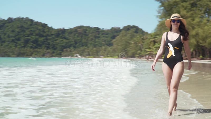 Joven camina por la playa de arena por mar