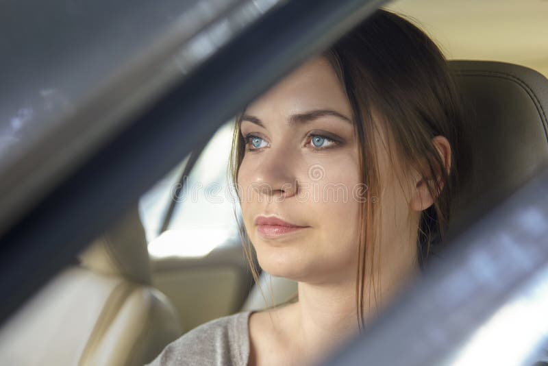 Joven caucásica mujer joven detrás del volante conduciendo un coche con expresión de cara seria imagenes de archivo Joven caucásica mujer joven detrás del volante conduciendo un coche con expresión de cara seria imagenes de archivo