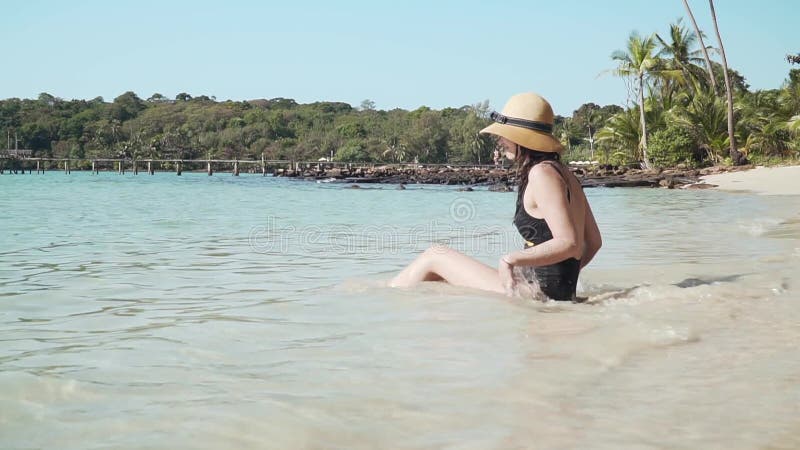 Joven caucásica sentada en la playa