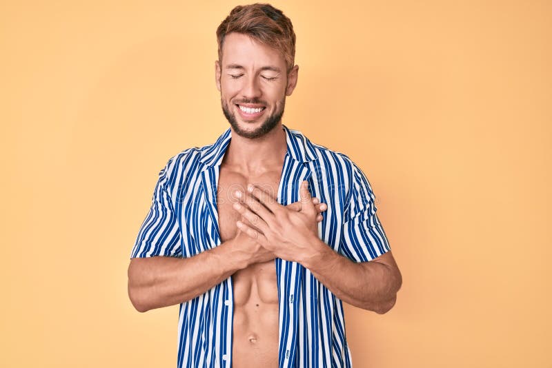 Joven caucásico con estilo de verano sonriendo con las manos en el pecho con los ojos cerrados y gestos agradecidos en la cara imágenes de archivo libres de regalías