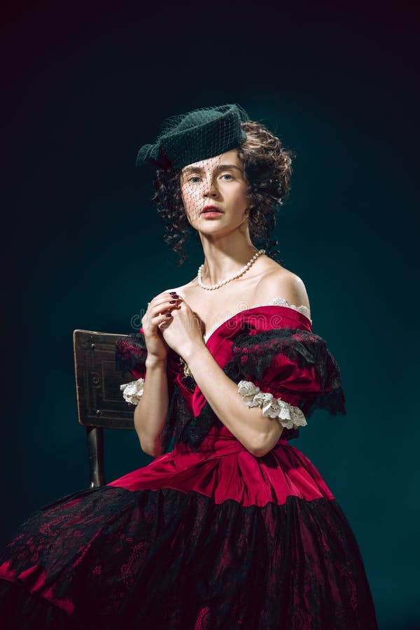 Joven como anna karenina sobre fondo azul oscuro. comparación de estilo retro del concepto de eras. 2. º licitación. joven mujer como anna karenina aislada en un fondo azul oscuro. bello modelo femenino como el personaje de la literatura muy antiguo.