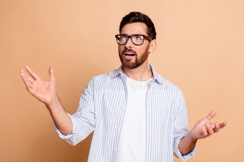 Joven con camisa casual a rayas haciendo gestos expresivos contra fondo neutral imágenes de archivo libres de regalías