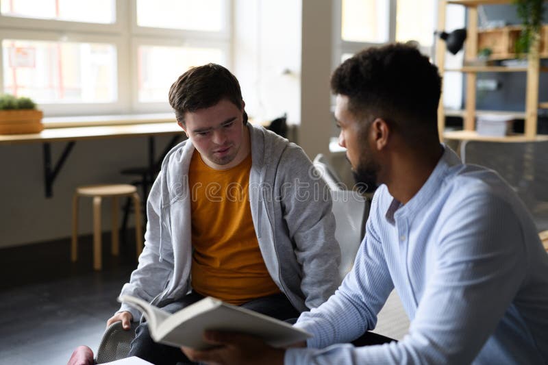 Joven con síndrome de Down estudiando con un profesor de educación especial en un aula de educación especial. fotos de archivo libres de regalías