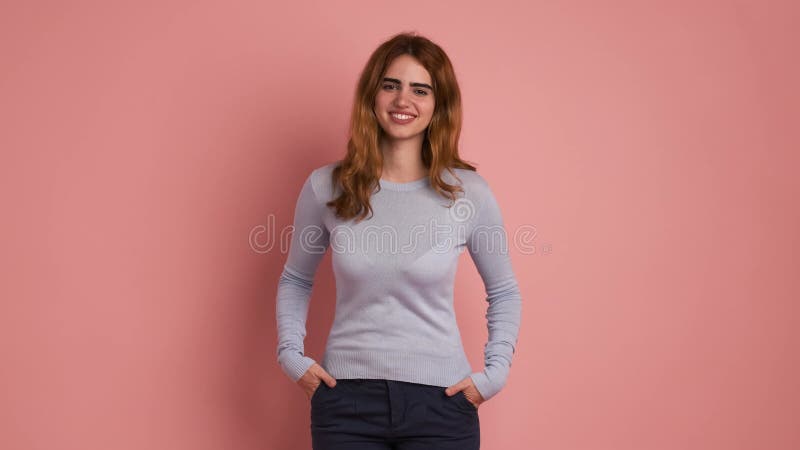 Joven de confianza con atuendo casual sonriendo en estudio metrajes