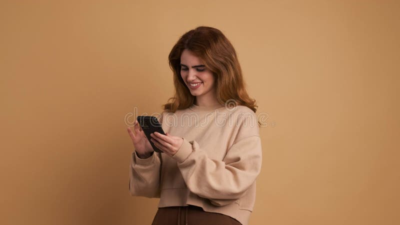 Joven distraída usando teléfono y sonriendo almacen de video