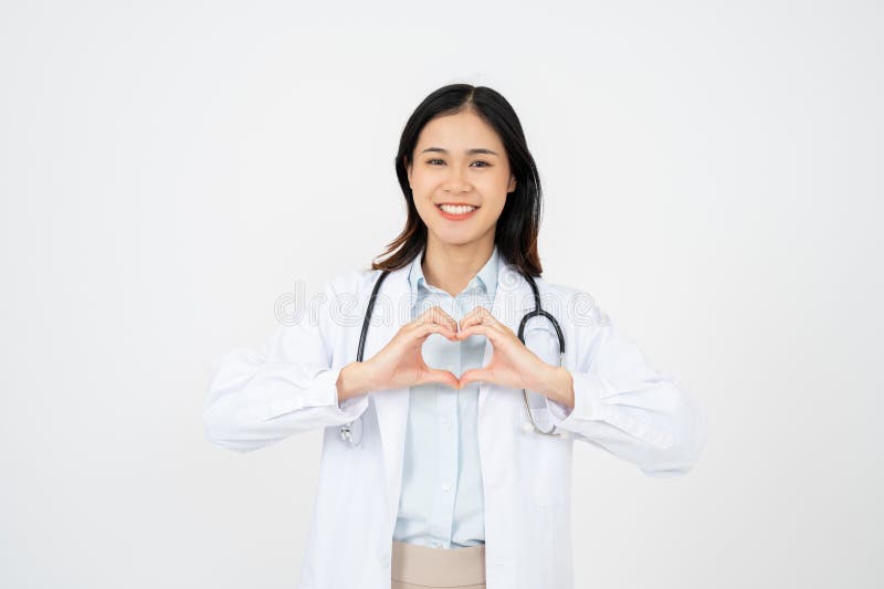 Joven doctora sobre fondo blanco sonriendo en el amor haciendo forma de símbolo cardíaco con las manos fotos de archivo libres de regalías