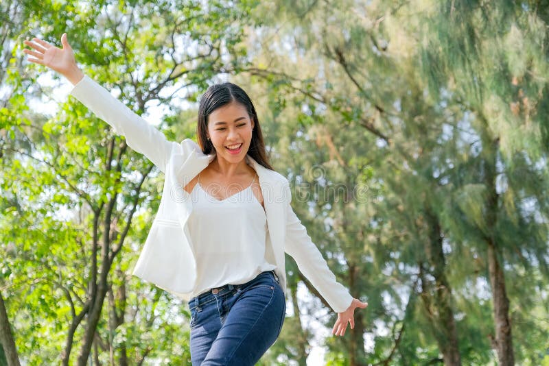 Joven empresaria asiática hermosa muestra acción de felicidad en el jardín con luz del día imagenes de archivo Joven empresaria asiática hermosa muestra acción de felicidad en el jardín con luz del día imagenes de archivo