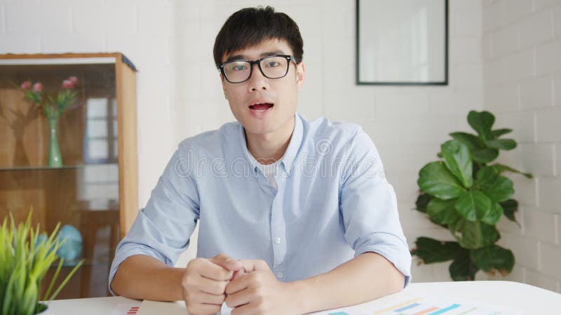 Joven empresario de asia usando laptop para computadora habla con sus colegas acerca del plan en una reunión de videollamadas mien almacen de video