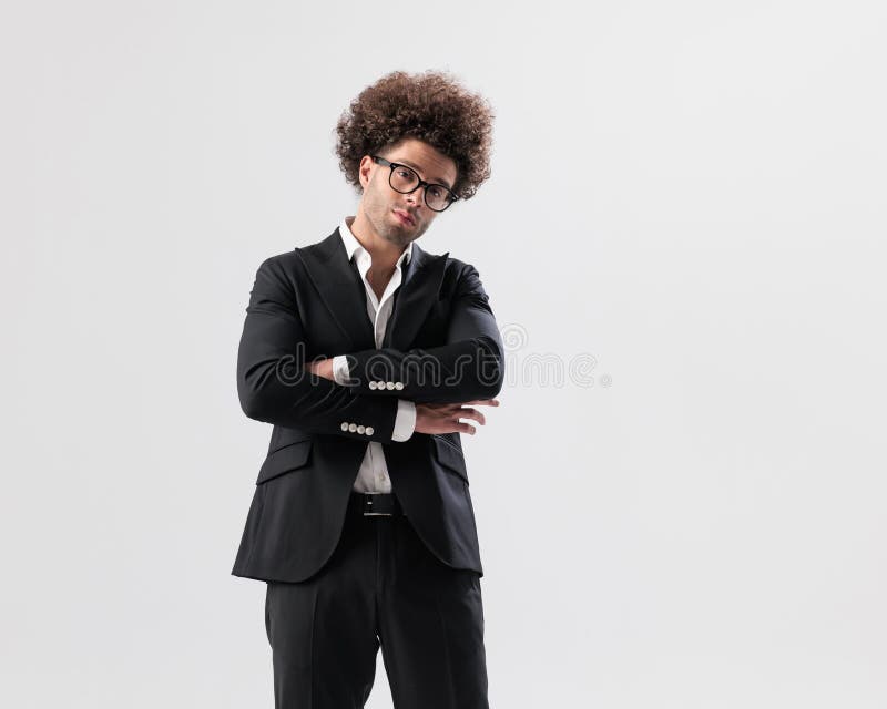 Joven empresario de confianza con gafas cruzando los brazos y sonriendo fotos de archivo