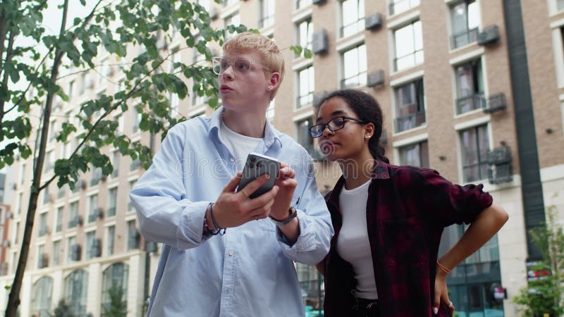 Joven explicando algo en el smartphone a una amiga metrajes