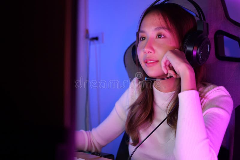 Joven hembra de streaming de juegos en línea en el ordenador en casa fotografía de archivo