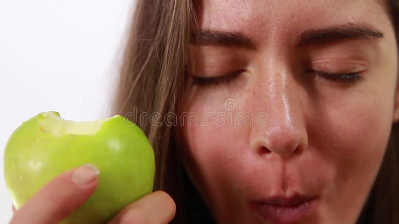 Joven hermosa chica muerde una manzana verde