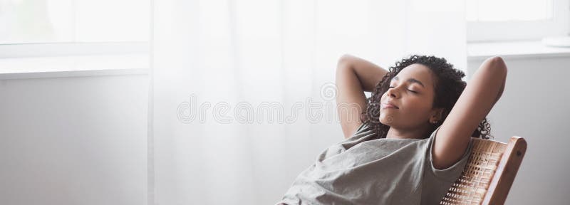 Joven hermosa mujer relajante en casa pancarta panorámica. linda chica afroamericana descansando en su habitación. fotografía de archivo libre de regalías