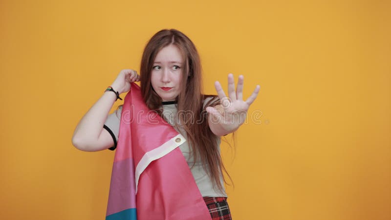 Joven mostrando gesto para dejar de mantener la bandera bisexual con palma