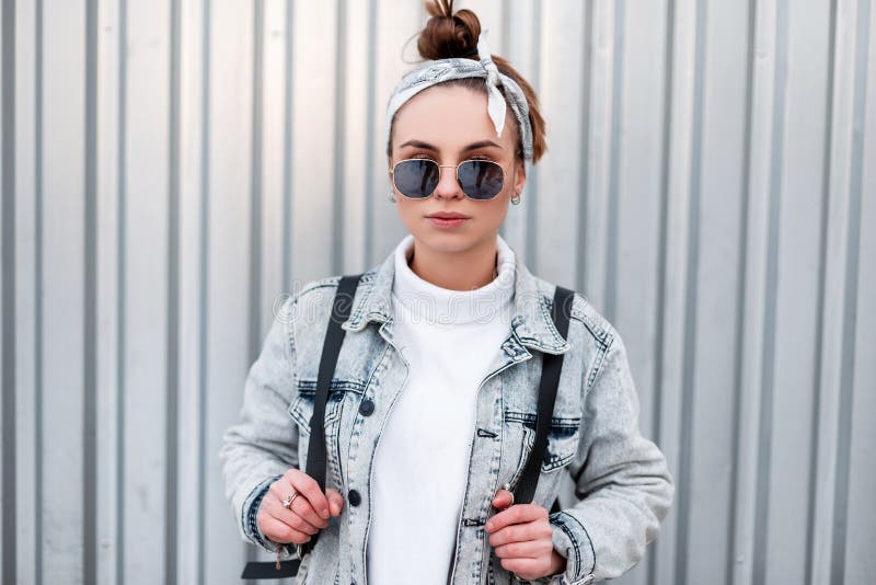 Mujer hipster con estilo joven fresco en ropa juvenil casual de moda en  gafas moradas de moda posa en la ciudad. modelo de moda de chica glamorosa  sexy estadounidense se sienta en