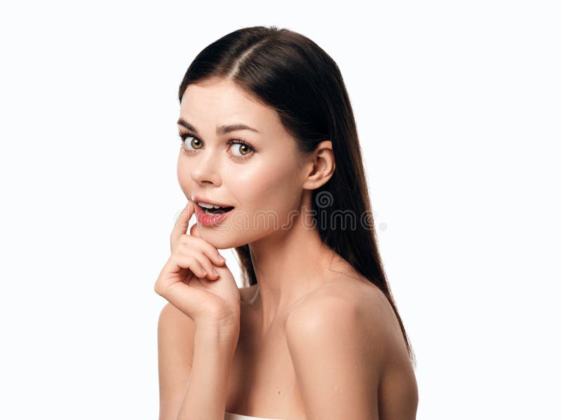Joven mujer posando con la mano en la barbilla y mirando a la cámara fondo blanco aislado imagen de archivo