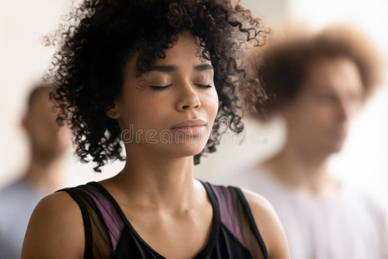 Joven pacífica afroamericana disfrutando de una profunda meditación. fotos de archivo