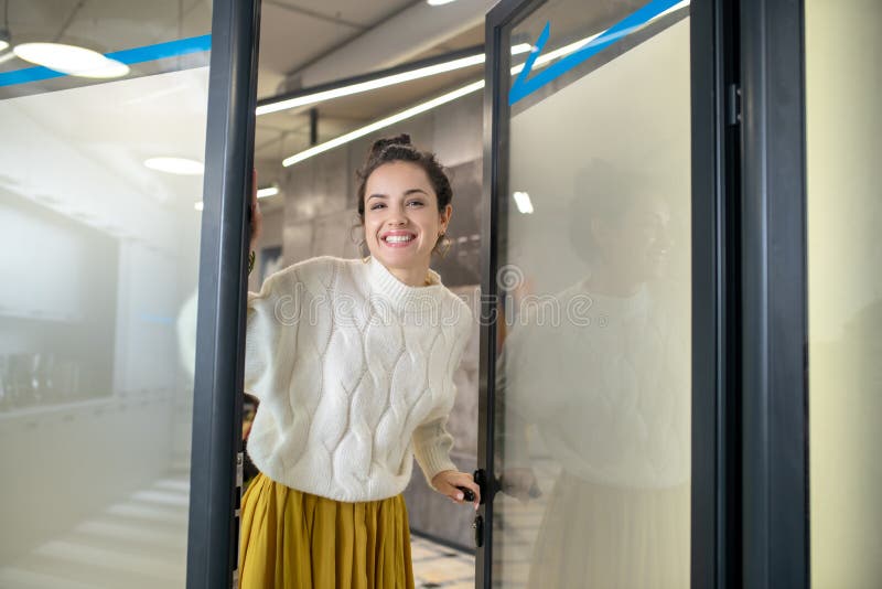 Joven parado en la puerta sonriendo alegremente imagen de archivo libre de regalías