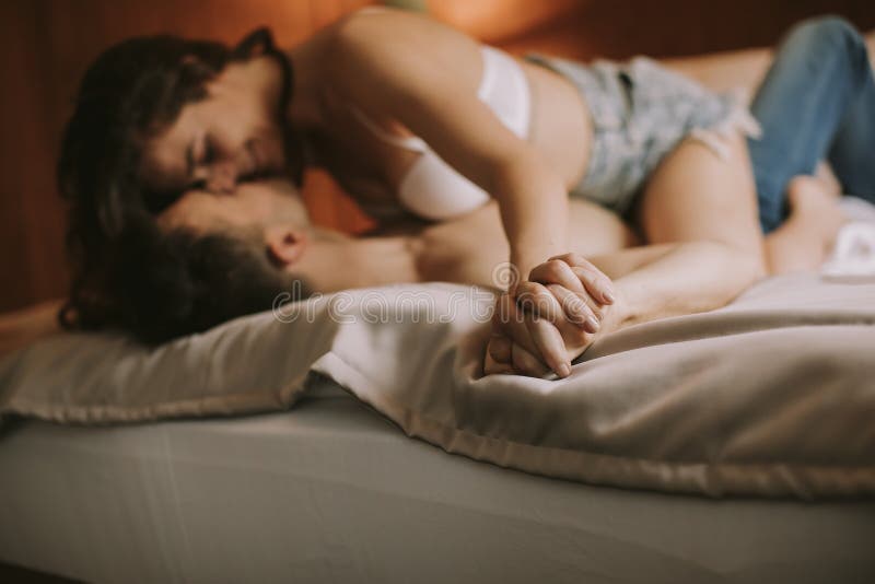 Joven pareja heterosexual en cama en dormitorio