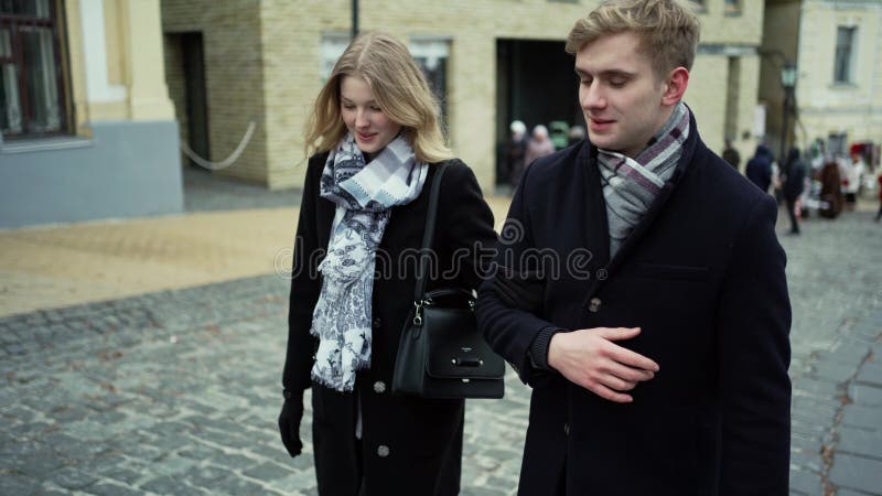 Joven pareja rubia caminando calle de la ciudad, mirándose con sonrisa metrajes