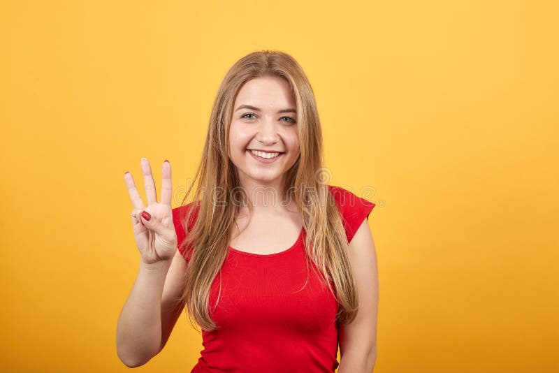 Joven rubia con camiseta roja sobre fondo naranja aislado muestra emociones fotos de archivo libres de regalías Joven rubia con camiseta roja sobre fondo naranja aislado muestra emociones fotos de archivo libres de regalías